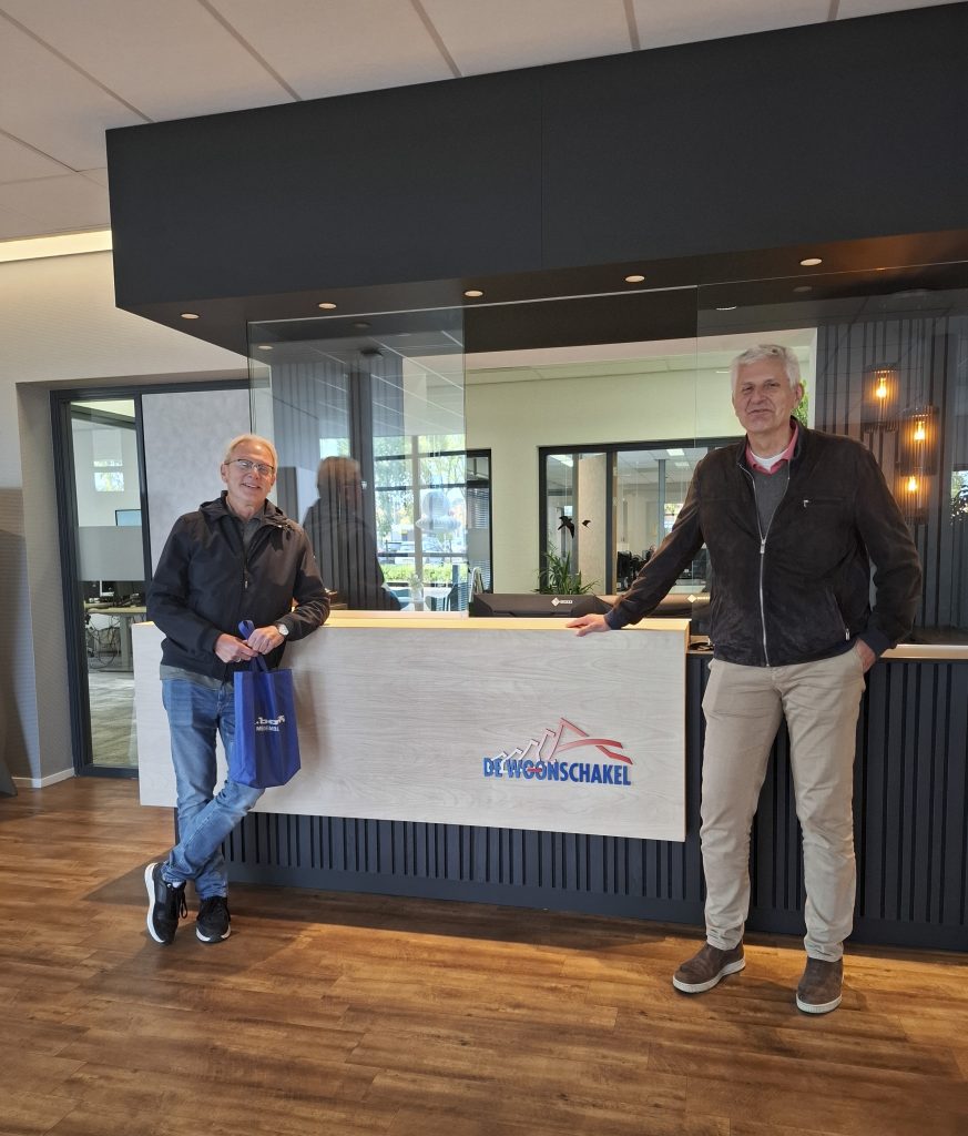 Dirk en Rob op de foto voor de balie van de woonschakel